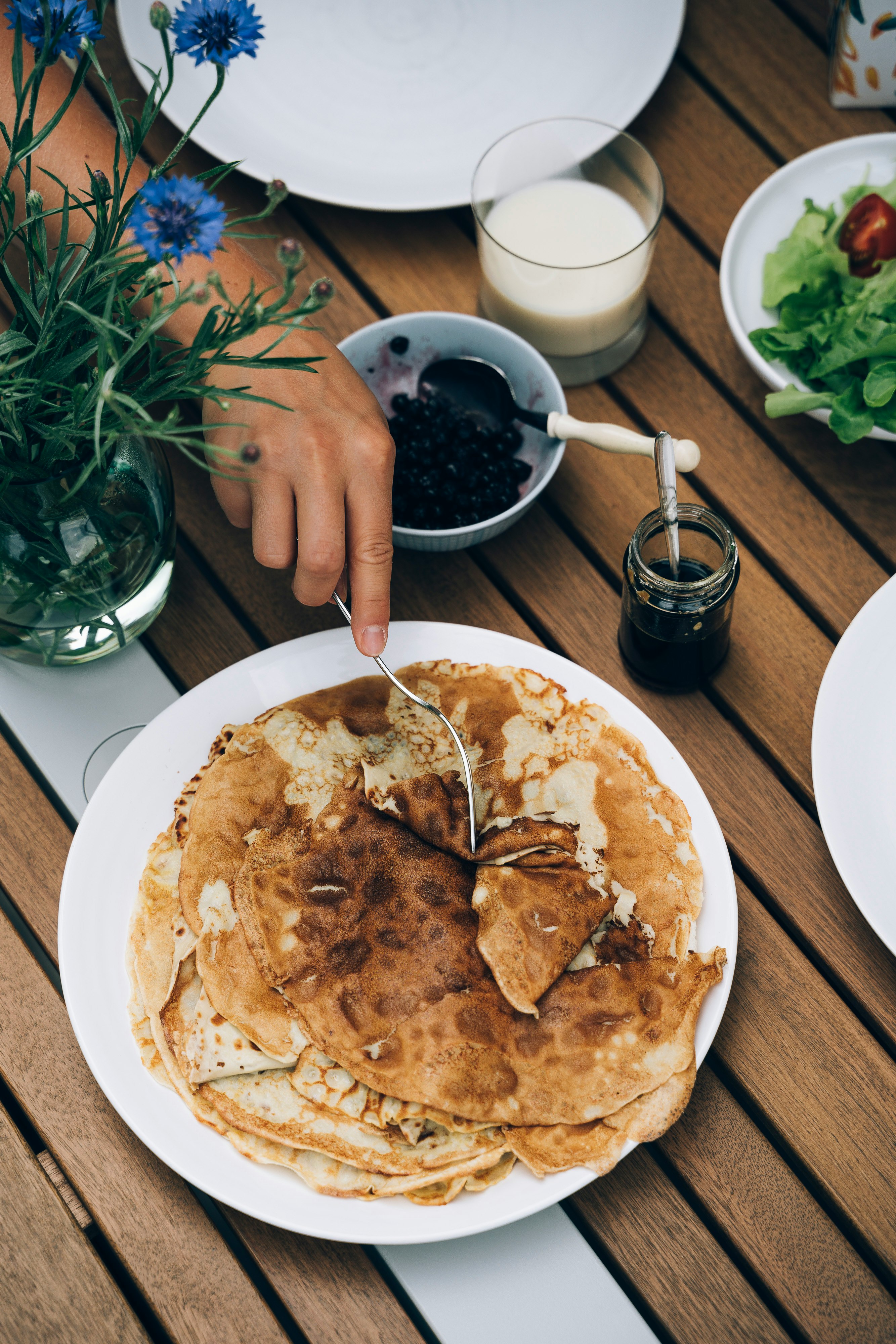 person holding fork on pancake